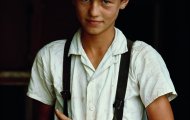 9.4. William Albert Allard - Pennsylvania - 1965. Un giovane amish con un cappello di paglia e le bretelle accarezza un porcellino dIndia